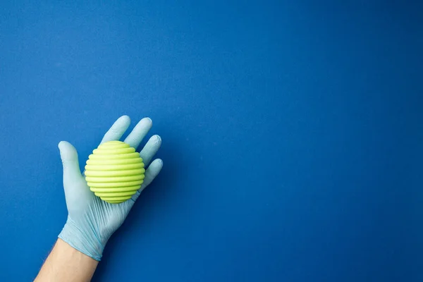 Hand in sterile glove studies the mock up of virus — Stock Photo, Image