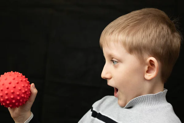 Niño pequeño sostiene un modelo de virus en sus manos —  Fotos de Stock