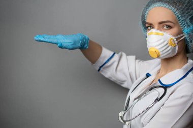 Gri arka planda tıbbi kıyafetler giyen hemşire..