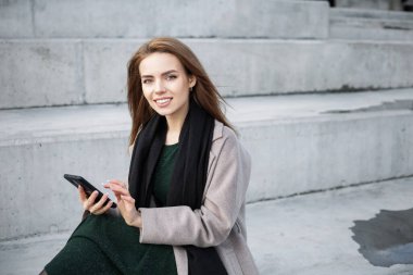 Akıllı telefondan mesaj yazan gülümseyen kız..