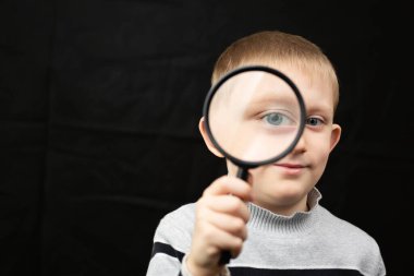 Çocuk büyüteçle bakıyor..