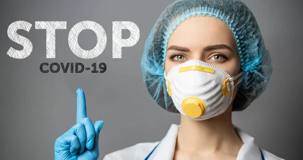 Sjuksköterska med handskar på mask med text stop covid-19 — Stockfoto