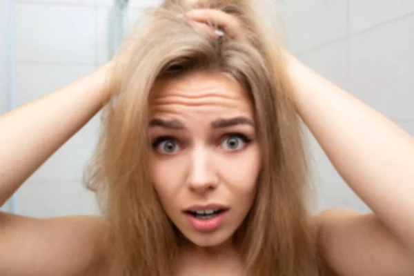Bella donna in bagno guarda capelli aggrovigliati. — Foto Stock