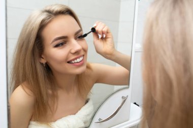 Güzel kız banyoda kirpiklerini boyuyor..