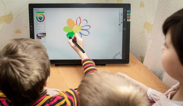 Kinderen tekenen een gekleurde bloem op grafische tablet. — Stockfoto