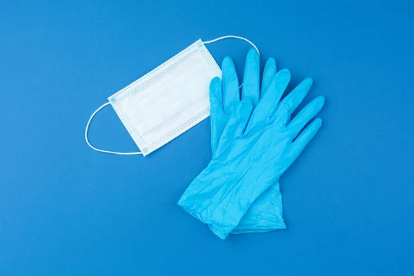 Medicinske handsker og maske på blå baggrund . - Stock-foto