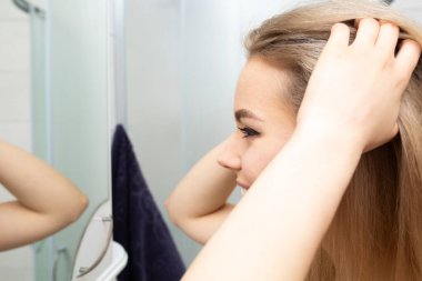 Güzel kız banyodaki aynaya bakar..