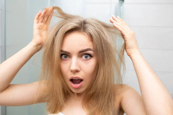 Bella donna in bagno guarda capelli aggrovigliati. — Foto Stock