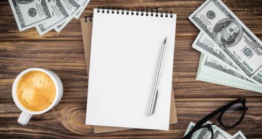 Tahta arka planda para olan sarmal defter