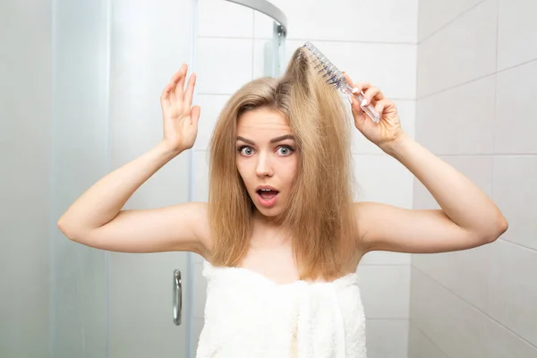 Mooie vrouw in badkamer kijkt naar verward haar. — Stockfoto