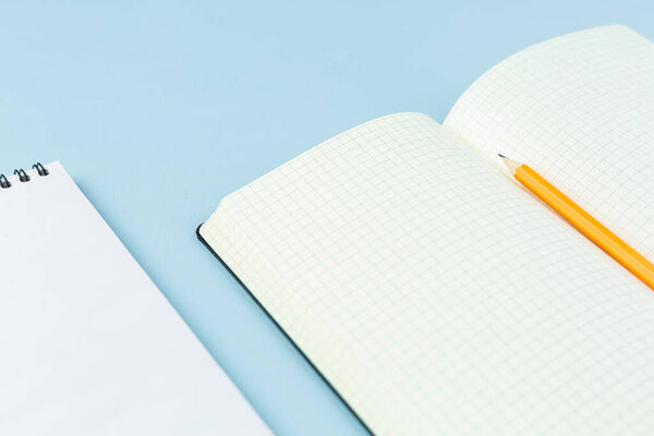 Откройте ноутбук с карандашом на синем фоне
.