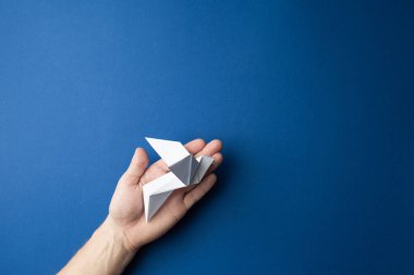 Mavi izole arkaplanda kağıt güvercin.