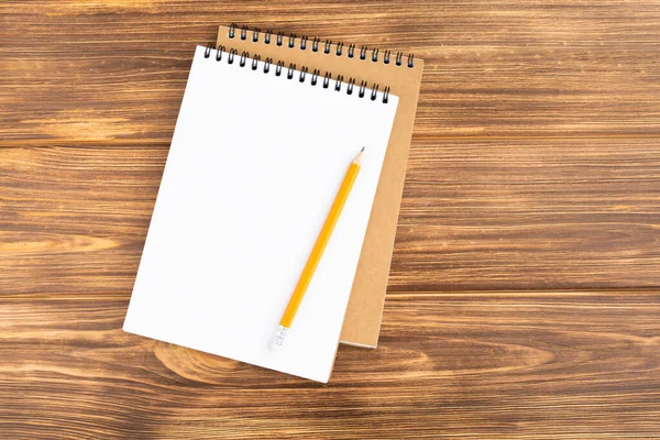 Cuaderno con lápiz sobre fondo de madera . — Foto de Stock
