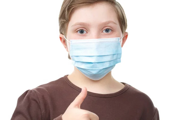 Barn i medicinsk mask visar tummen upp. — Stockfoto