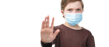 Tıbbi maskeli çocuk dur işaretine avuç içi koymuş..