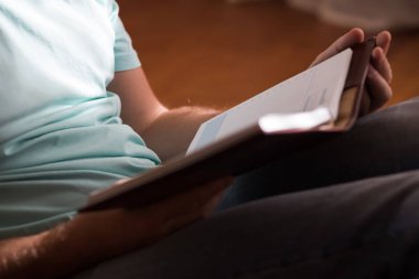 Adam evde kahverengi yerdeki onun elinde eski ciltli kitap holding okuma. Aile içi yaşam tarzı. Eğitim kavramı.