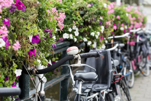 Амстердам Голландия Нидерланды дома, цветущие цветы и велосипеды рядом со знаменитыми каналами всемирного наследия UNESCO Singel с типичными дачными плавучими домами — стоковое фото
