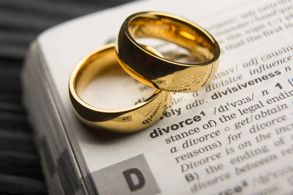 Scheidings- en scheidingsconcept. Twee gouden trouwringen. Woordenboek definitie. — Stockfoto