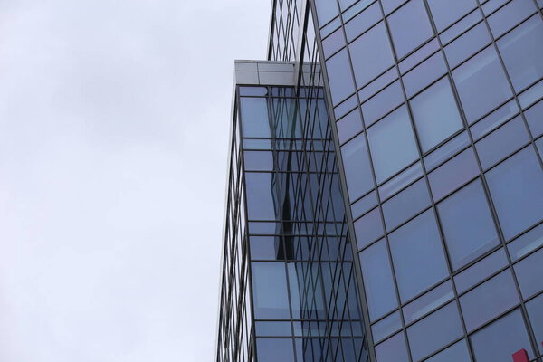 Abstract business modern city urban futuristic architecture background, motion blur, reflection in glass of high rise skyscraper facade, toned blue picture with bokeh. Real estate concept
