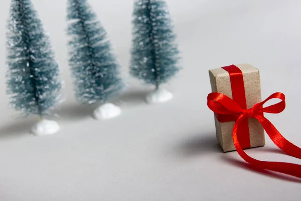 Boże Narodzenie prezent pudełko z czerwoną wstążką na białym tle i choinkę. Skopiuj miejsce na tekst. Skupienie selektywne. — Zdjęcie stockowe