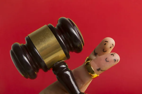 Doeleinde devorce creatief concept. Geschilderde gelukkige vingers smiley in liefde tegen rode achtergrond met rechtbank weegschaal — Stockfoto
