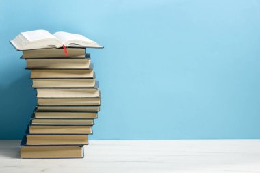 Kaliteli eski ciltli kitaplar, günlük ahşap güverte masasında ve kırmızı arka planda sayfaları olan kompozisyon. Kitaplar istifleniyor. Okula dönelim. Uzayı kopyala Eğitim geçmişi.