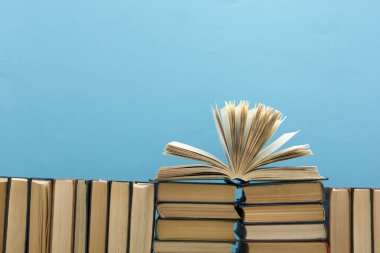 Kaliteli eski ciltli kitaplar, günlük ahşap güverte masasında ve kırmızı arka planda sayfaları olan kompozisyon. Kitaplar istifleniyor. Okula dönelim. Uzayı kopyala Eğitim geçmişi.