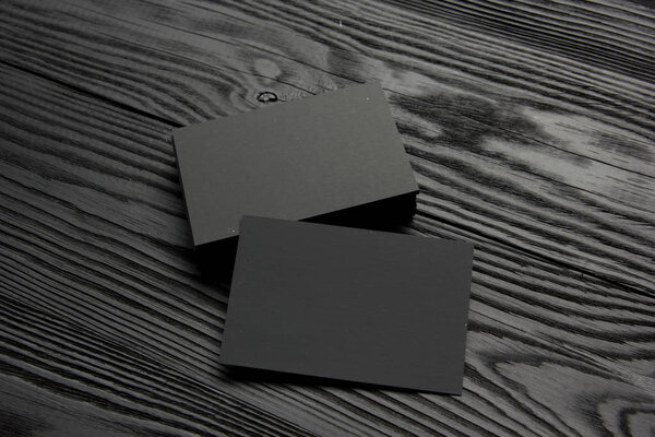 Визитка пустая на черном деревянном фоне. Корпоративная канцелярия, Брендинговый макет. Творческий дизайнерский стол. Плоский лежал. Копирование текста
