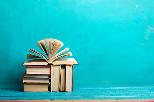 Composition avec de vieux livres à dos rigide vintage, un journal, des pages ventilées sur une table de terrasse en bois et un fond rouge. Des livres empilés. Je retourne à l'école. Espace de copie. Formation initiale . — Photo