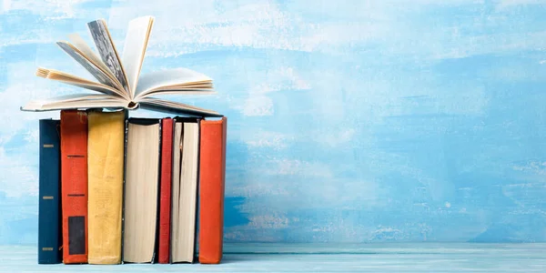 Composición con antiguos libros antiguos de tapa dura, diario, páginas ventiladas en la mesa de madera y fondo rojo. Libros apilados. De vuelta a la escuela. Copiar espacio. Formación profesional . — Foto de Stock