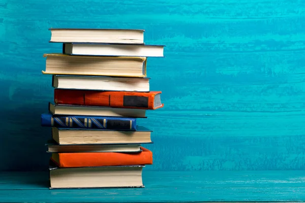 Összetétel régi keménykötésű könyvekkel, naplóval, fanned oldalakkal a fa fedélzet asztalon és piros háttérrel. Könyvhalmozás. Vissza a suliba. Fénymásolási tér. Oktatási háttér. — Stock Fotó