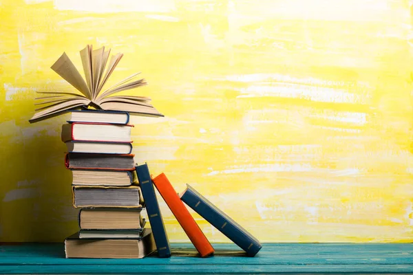 ヴィンテージ古いハードバックの本、日記、木製のデッキテーブルと赤の背景にファンのページと構成。積み重ね。学校に戻る。コピースペース。教育の背景. — ストック写真