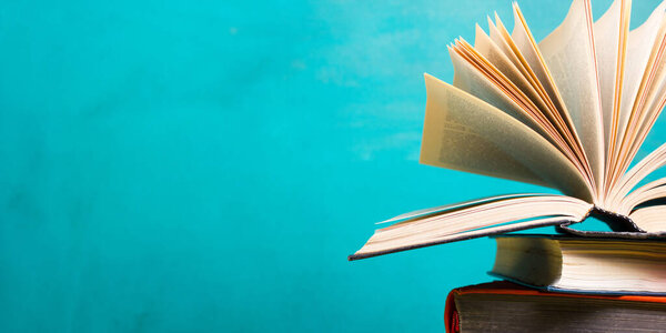 Композиция с старинными книгами в твёрдом переплете, дневником, раздутыми страницами на деревянном столе и абстрактным фоном. Складывание книг. Возвращайся в школу. Скопируй пространство. Образование
.