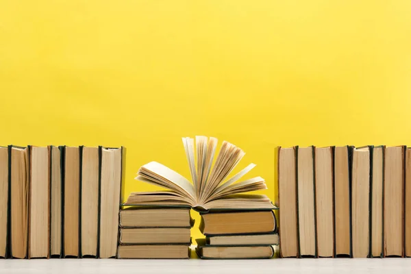 Composition with vintage old hardback books, diary, fanned pages on wooden deck table and abstract background. Books stacking. Back to school. Copy Space. Education background. Stock Image