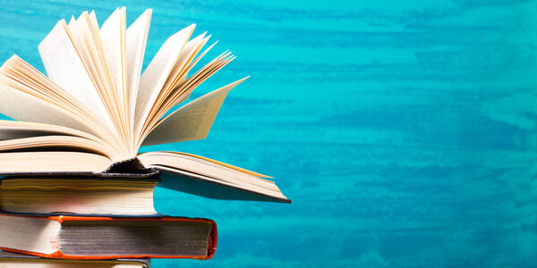 Композиция с старинными книгами в твёрдом переплете, дневником, раздутыми страницами на деревянном столе и абстрактным фоном. Складывание книг. Возвращайся в школу. Скопируй пространство. Образование
.