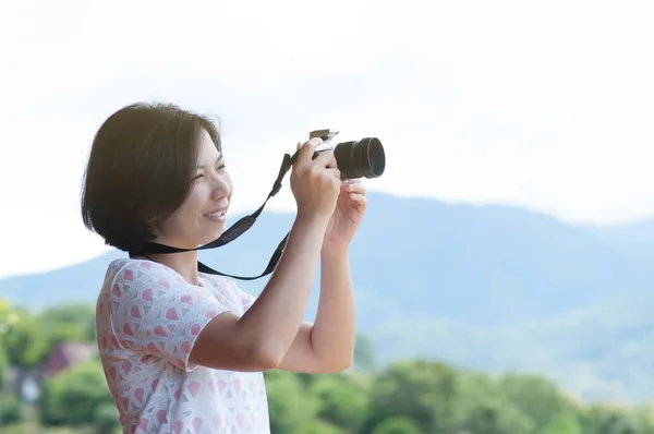 Joven mujer asiática sosteniendo cámara . — Foto de Stock