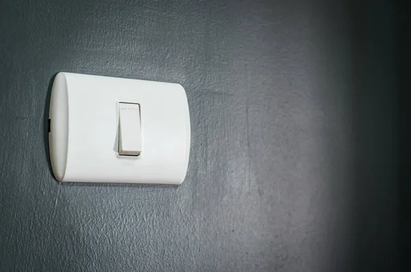 Lighting switch on dark blue wall. — Stock Photo, Image