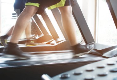 Koşu bandı makinede çalışan insanlar.