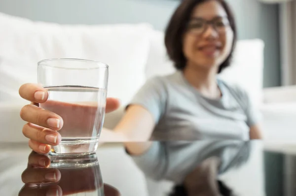 Азиатские очки женщина держит стакан воды — стоковое фото