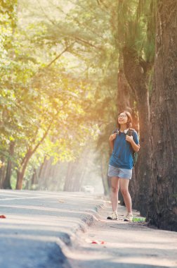 Ayakta ve taze hava nefes sırt çantası ile Asyalı kadın uzun yürüyüşe çıkan kimse