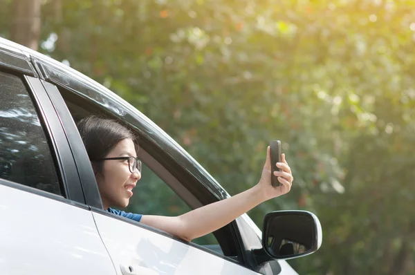 Asiatiska resenären kvinna tar foto från inne i bilen med cell- — Stockfoto