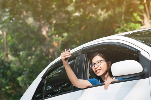 Asiatiska resenären kvinna tar foto från inne i bilen med cell- — Stockfoto