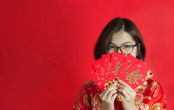 Kırmızı zarf tutan cheongsam kadınla Asya gözlük .