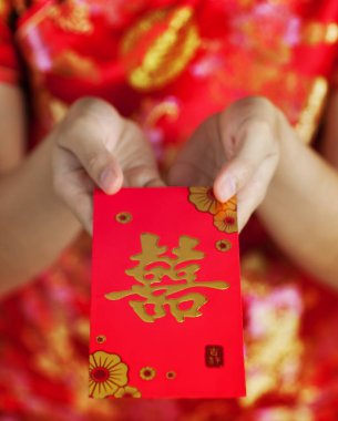 Kırmızı zarf kırmızı b üzerinde tutarak cheongsam kadınla Asya gözlük