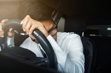 O sürüş sırasında migren baş ağrısı olan Asya iş adamı