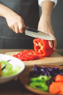 Kadın kırmızı biber kesme. Vegan yemek yemek. ile sağlıklı