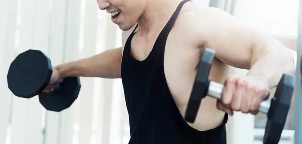 Homem muscular asiático levantando halteres no ginásio. espaço de cópia . — Fotografia de Stock