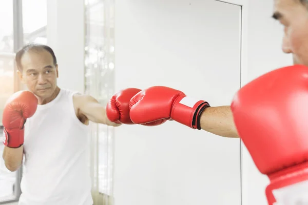 Retrato de hombre de combate senior asiático perforando con gl de boxeo rojo — Foto de Stock