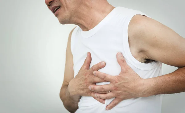 Asiático mayor hombre tener un ataque al corazón mientras se ejercita en blanco — Foto de Stock