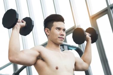 Asya kaslı adam spor salonunda halter kaldırma. kopya alanı.